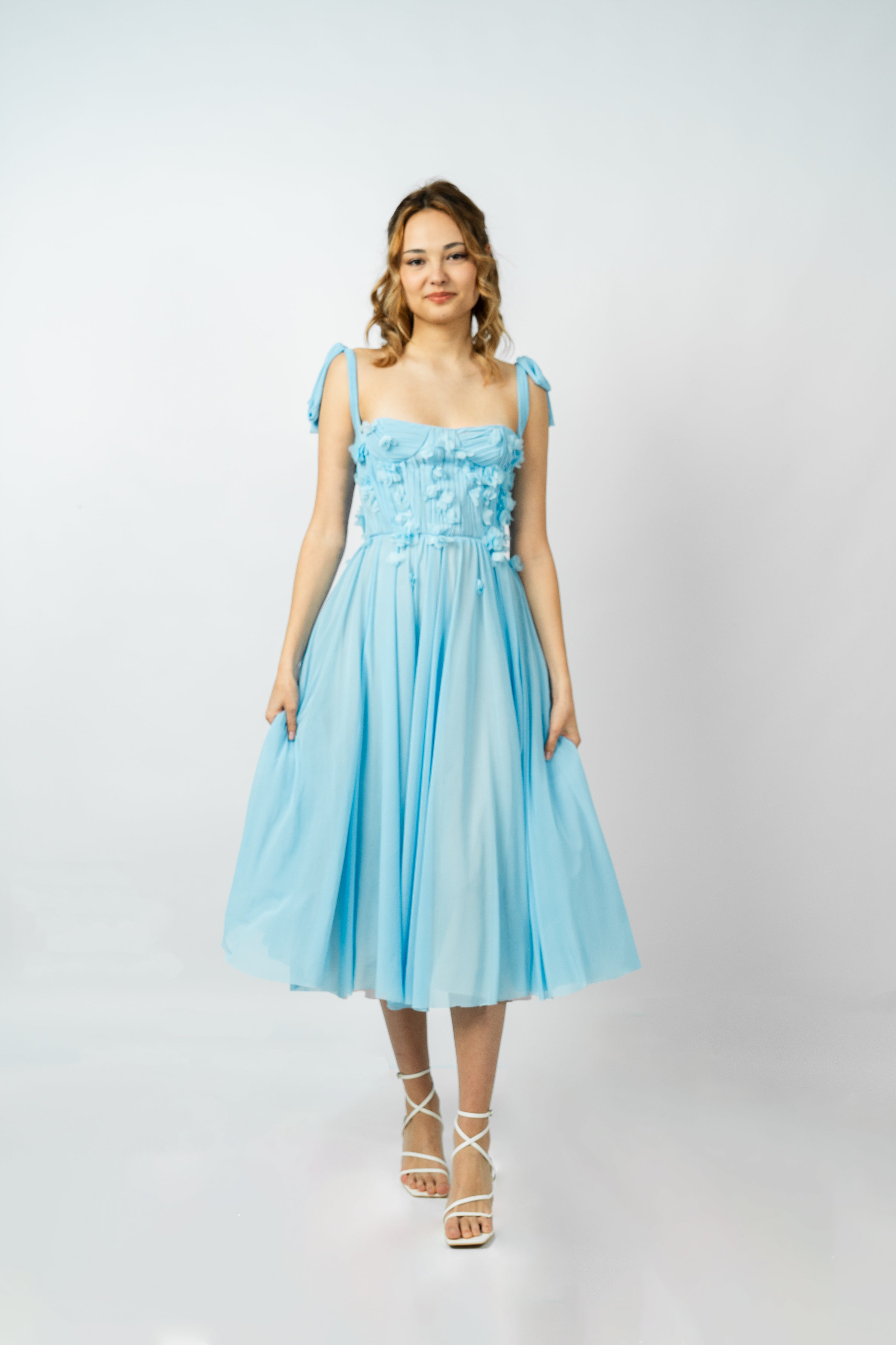 Woman wearing a light blue dress on a white background