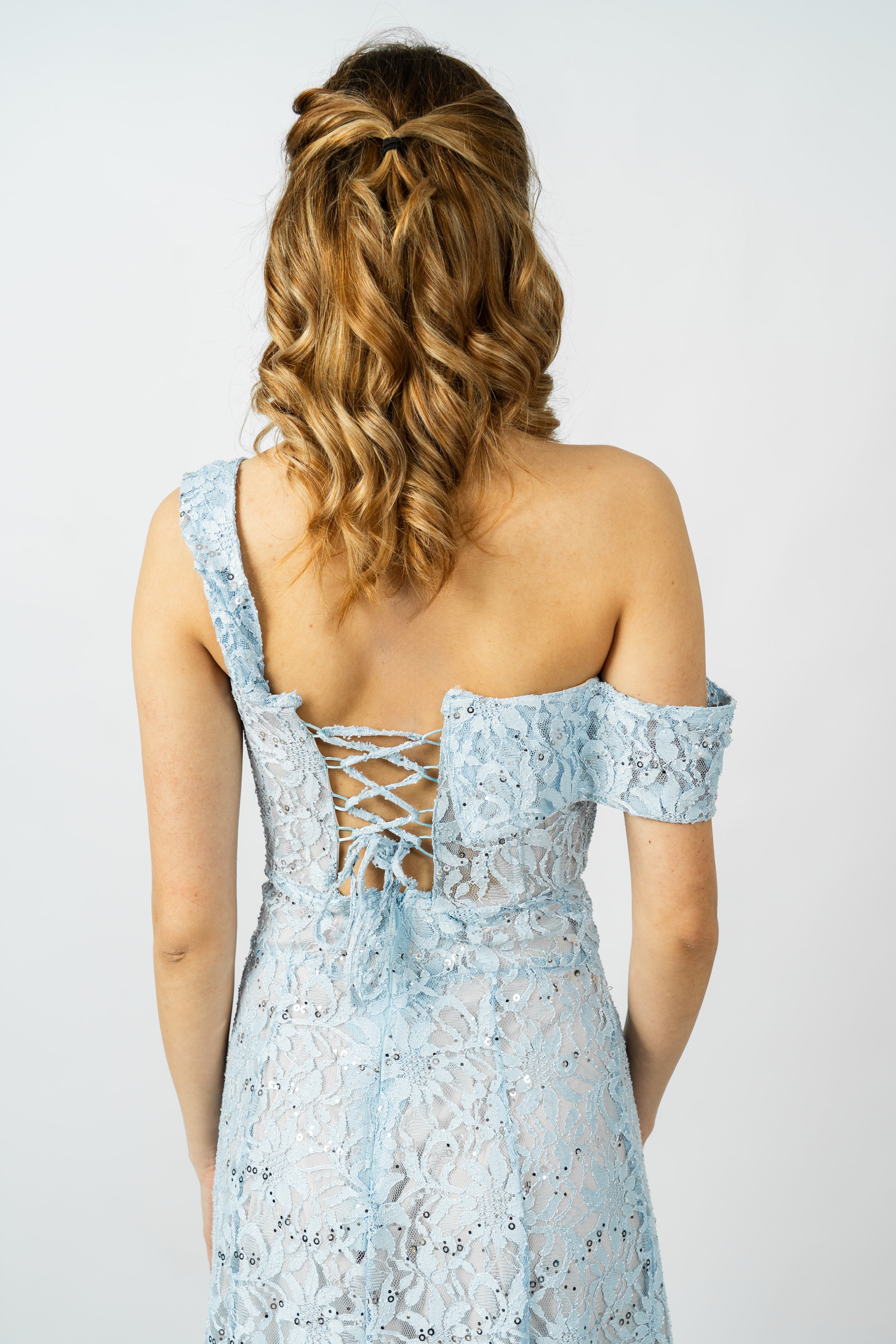 Light blue lace dress with criss-cross back on a plain background